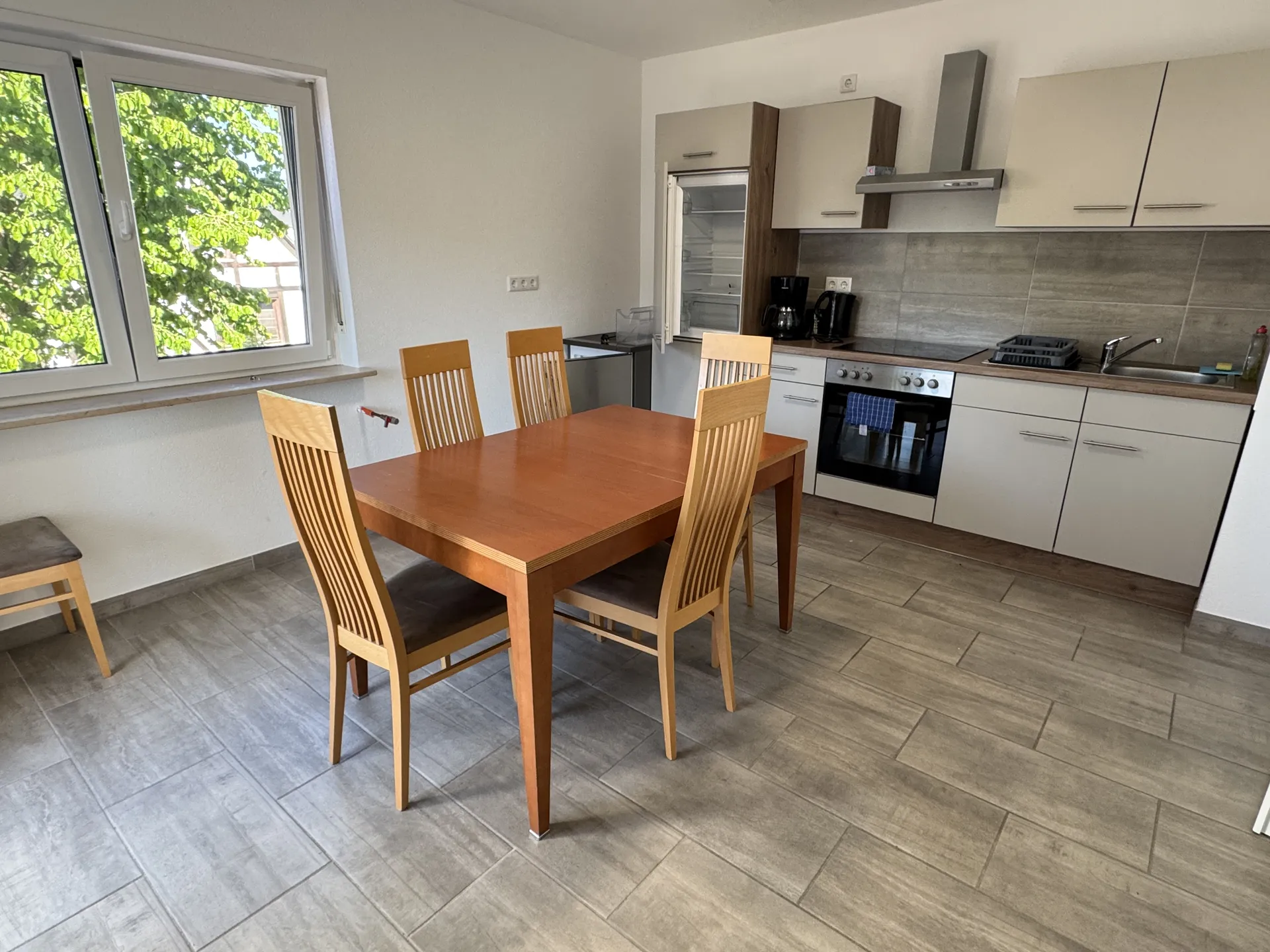 Große Wohnküche der Monteurwohnung nahe Friedberg mit Einbauküche, Esstisch und Stühlen.