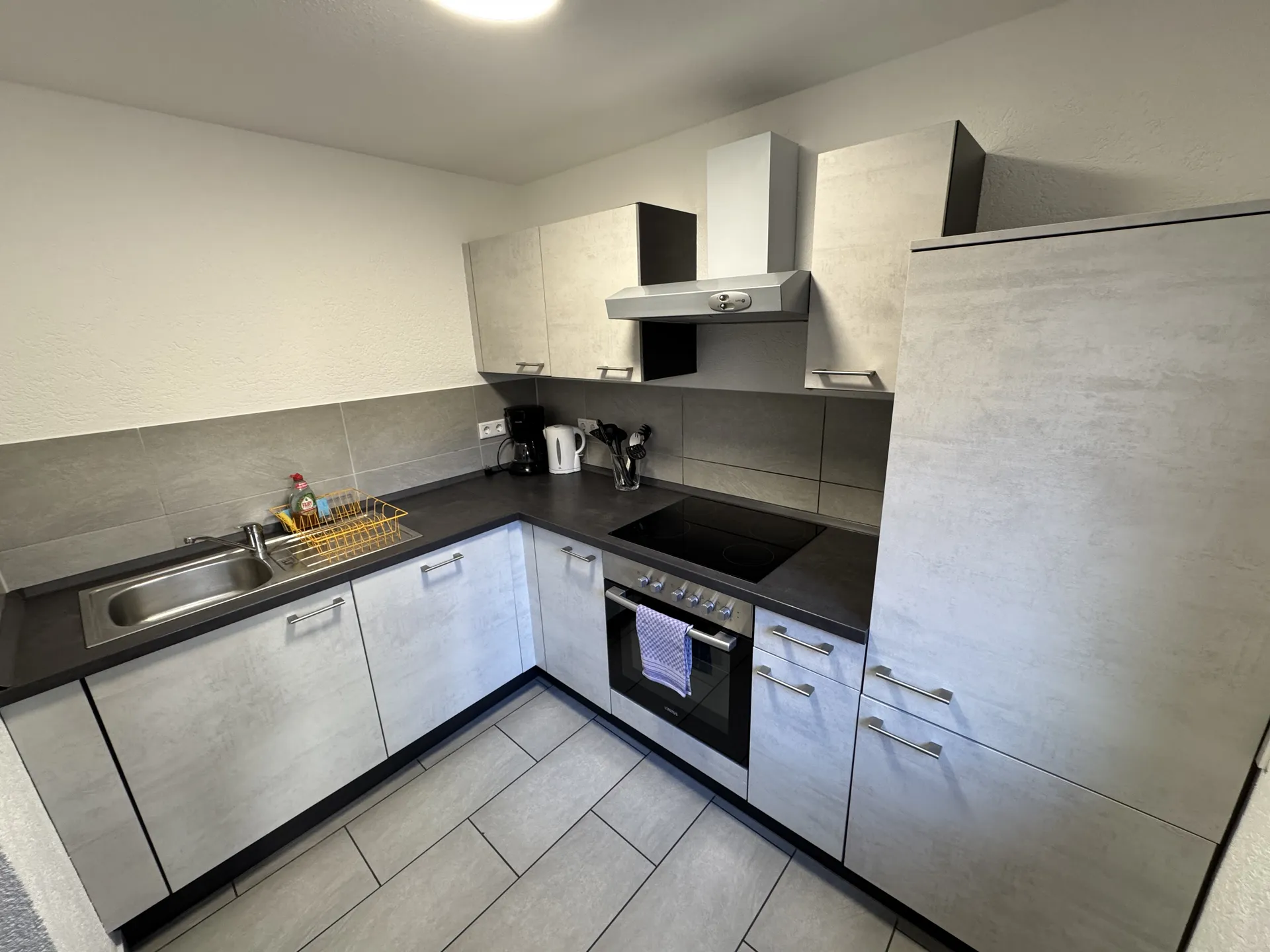 Moderne Einbauküche der Monteurwohnung in Fernwald mit Ceranfeld, Backofen und Spüle