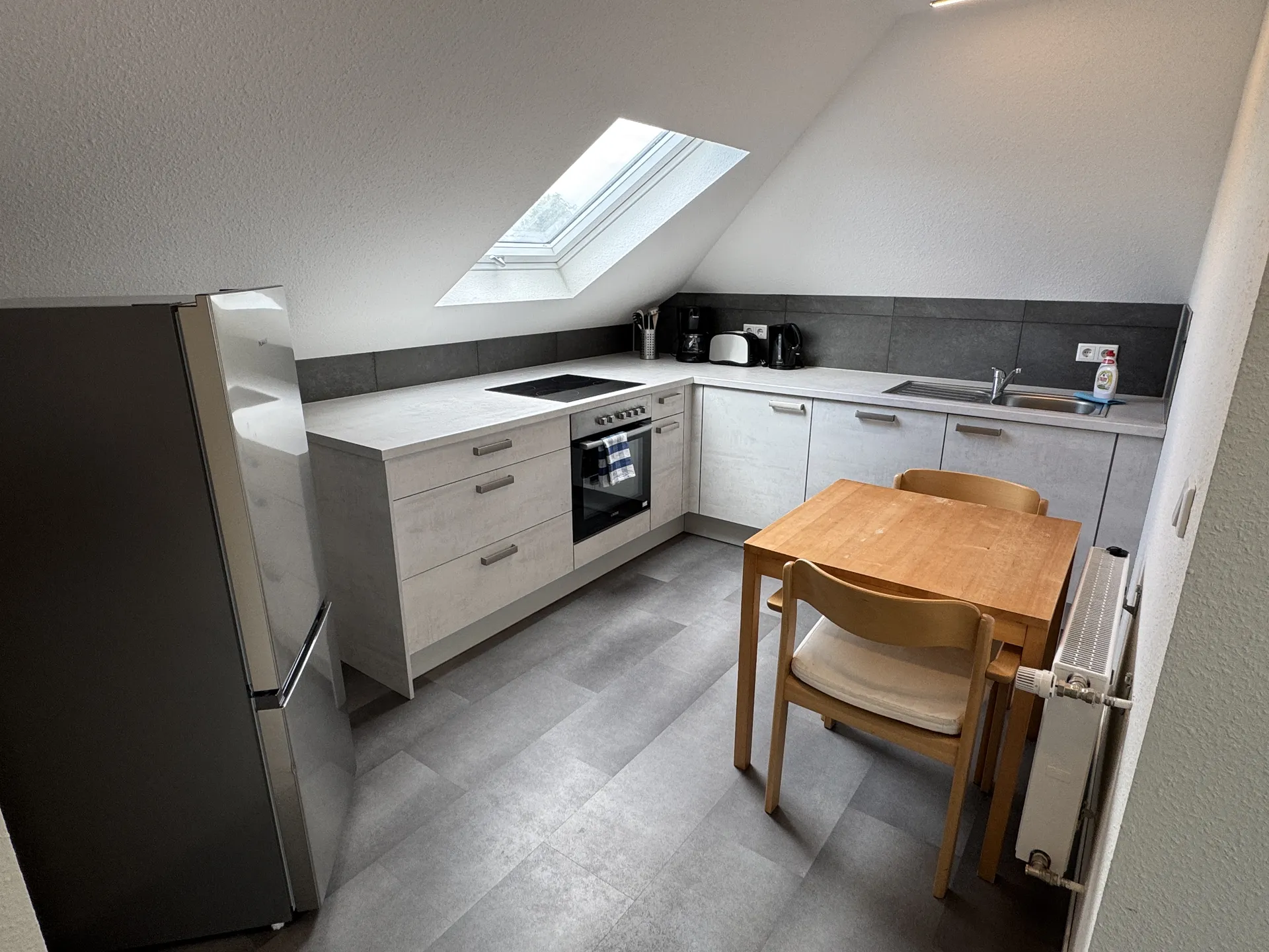 Moderne Dachgeschossküche im Monteurzimmer bei Lich mit Einbauküche und Essplatz