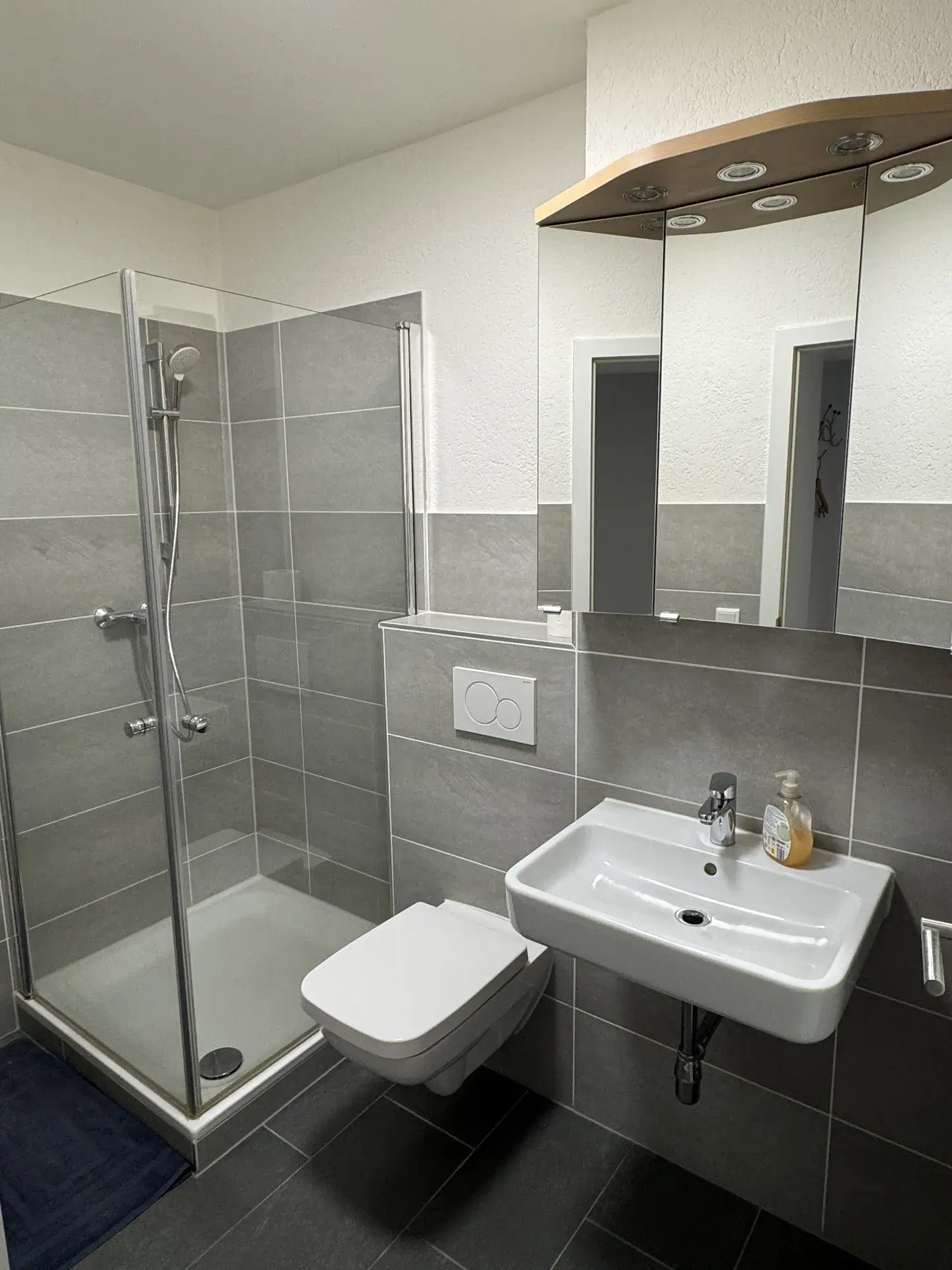 Modernes Bad des Monteurzimmers nahe Wetzlar mit bodennaher Dusche, WC und Waschbecken